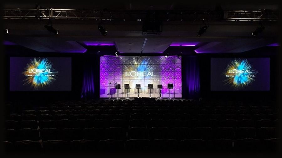Executive panel session with multi-screen conference stage